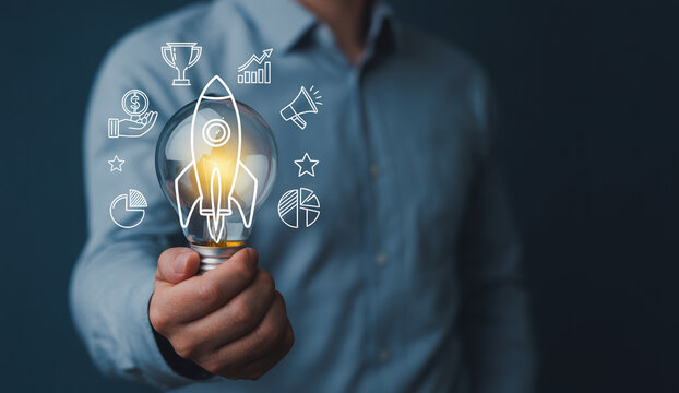 Entrepreneur holding lightbulb with business growth icons hovering above.