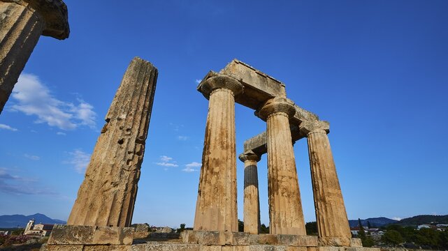 Archaic Temple of Apollo, Doric columns, Historical temple columns with a background of mountain landscape and blue sky, Archaeological site, Archea Korinthos, Corinth, Peloponnese, Greece