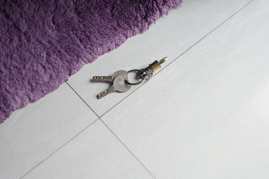 Keys lying on a floor near a purple rug. lost key concept 