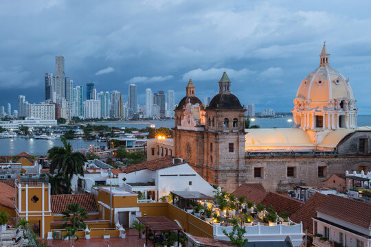 Blue hour view of Cartagena's historic walled city with the Cathedral of Saint Catherine of Alexandria and the modern Bocagrande skyline in the background, Cartagena, Colombia