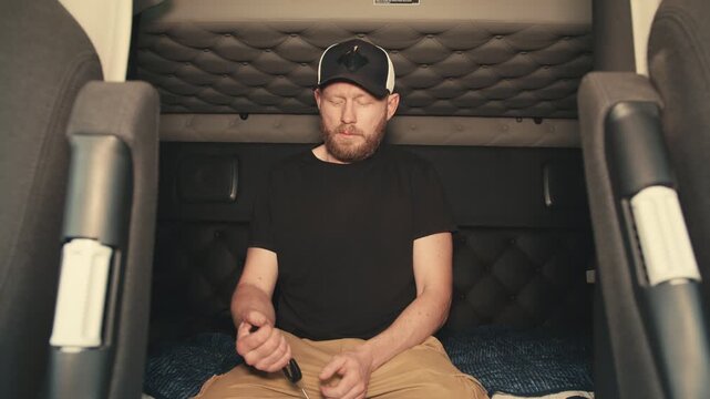 Truck driver waking up in sleeper cabin