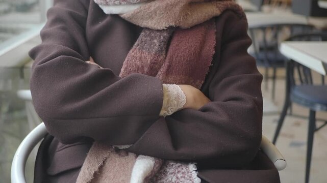 Woman sitting in cafe with crossed arms