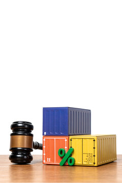 Green percentage sign and shipping containers next to a gavel with copy space. Import tariffs, customs duties, maritime law, trade taxation, and global supply chain regulations concept.