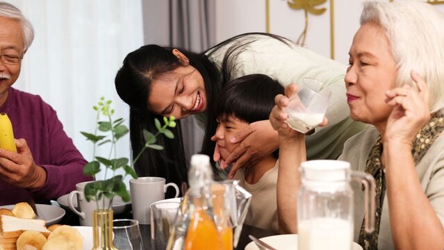 Multigenerational Asian Family Sharing Affectionate Moments During Breakfast at Home