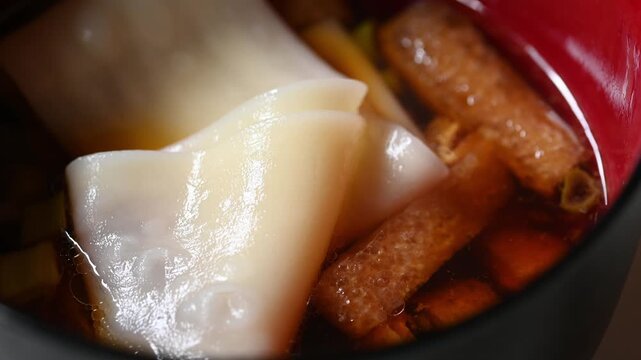 熱々の幅広うどんを持ち上げるクローズアップ