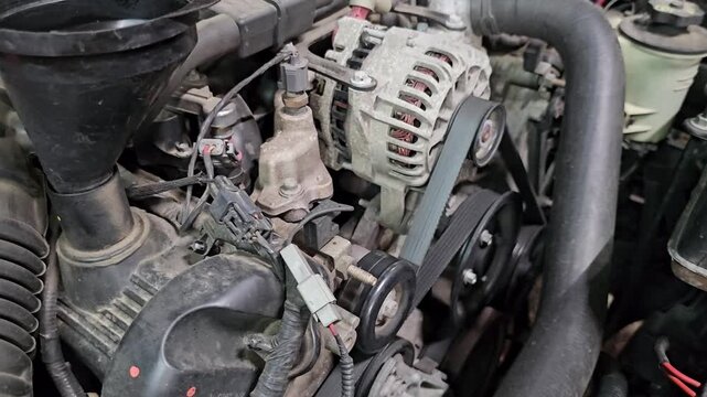 Car engine parts being inspected in a garage setting during afternoon hours