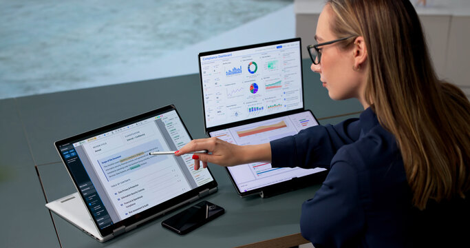 Woman Uses Dual Touchscreen Laptop To Monitor Compliance