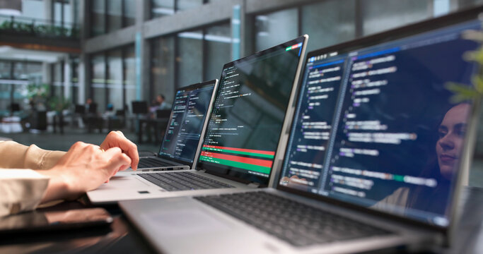 Woman Developer Compares Code Changes On Laptop
