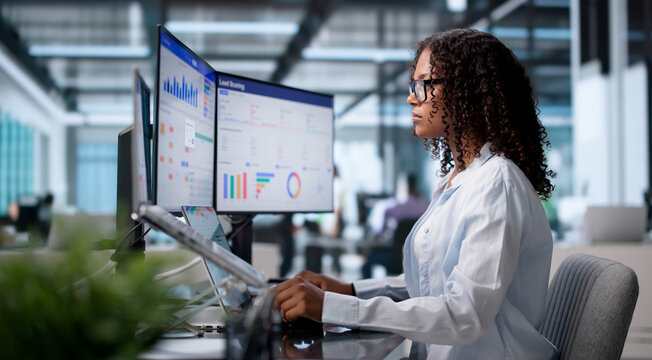 Young Sales Manager Reviews Client Data Using Laptop