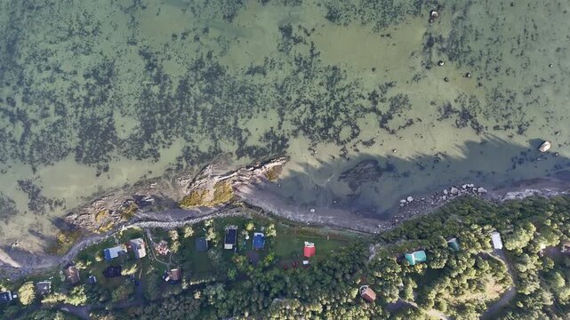 Aerial view of Bic National Park coastline, forest, campground and calm bay under blue sky. g.