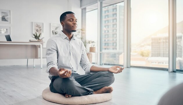 Man in white shirt meditating on wooden floor indoors