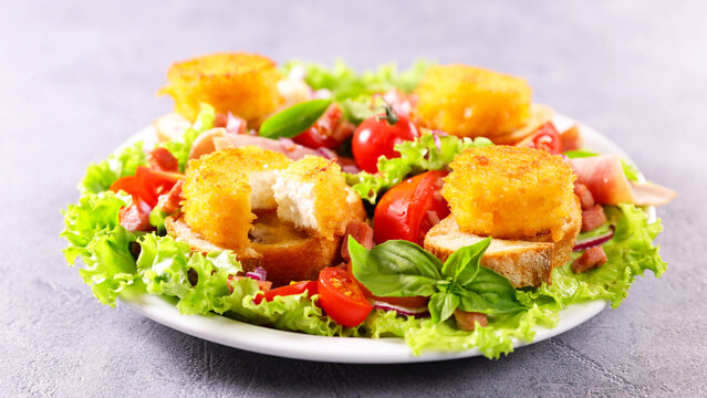 Warm goat cheese salad with fried breaded cheese on toast and tomatoes