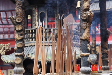 Naklejka premium Incense sticks burning with smoke in the temple at Mount Qingcheng in Dujiangyan, Chengdu, Sichuan Province of China