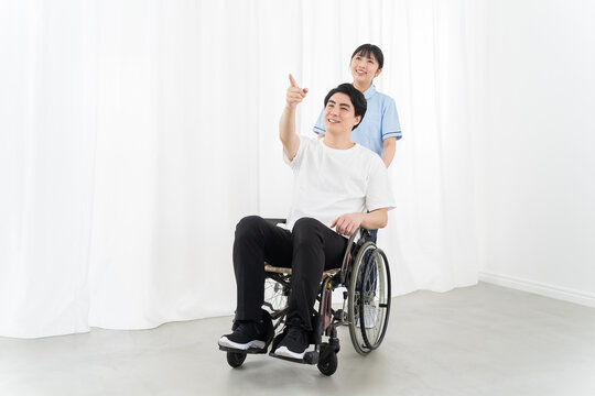 介護スタッフと車椅子の若い男性