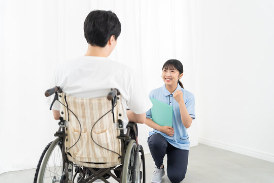 介護スタッフと車椅子の若い男性