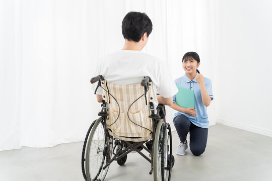 介護スタッフと車椅子の若い男性