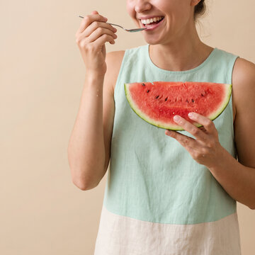 Woman eating fresh watermelon slice. Happy person enjoying healthy summer fruit snack.