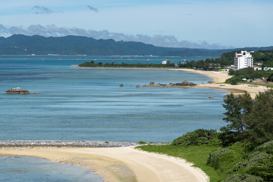 高台から見える奥の山々と遠浅のエメラルドグリーンの海といくつも連なる白い砂浜