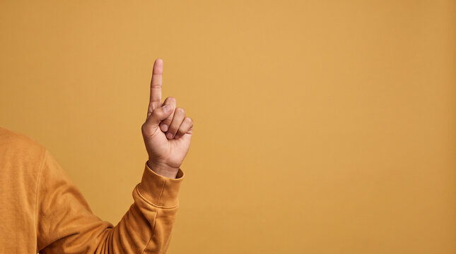 Person pointing finger up. Hand gesture indicating important information or attention.