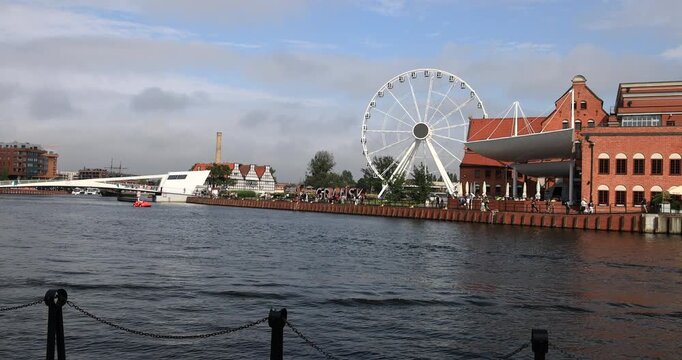 Gdansk Poland river ferris wheel historic district. Baltic coast northern Poland. World War II started with German invasion. Historical buildings, tourist attractions. Shipping transportation.