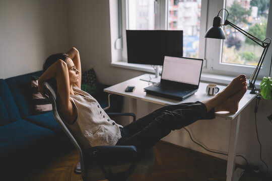 Woman relaxing with feet on desk after work