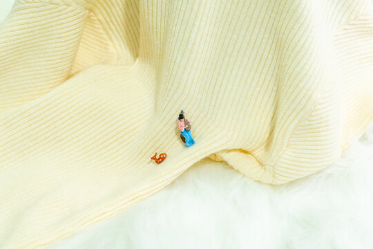 Creative micro still life of pipa figurine on cream rib knit fabric
