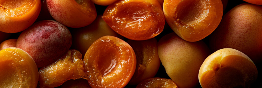 ripe halved apricots full frame background, fresh pitted apricots with juicy texture, colorful summer apricots overhead food background