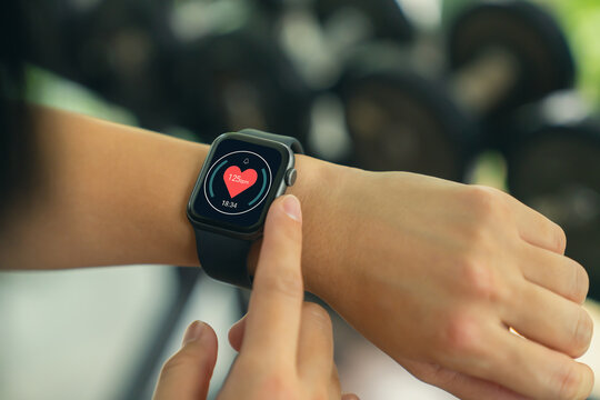 Hand of woman using smartwatch to monitor heart rate and health data