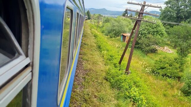 Scenic view from a moving passenger train window in the green countryside.