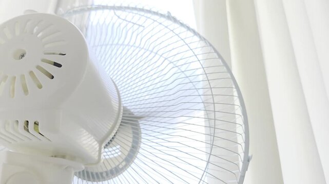 Electric Fan Operating Near Window ir Bright Interior