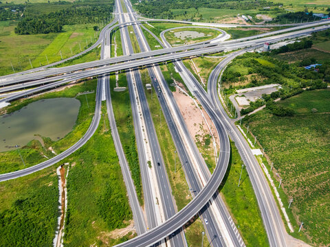 Drone shot a large highway interchange crossing over green farmlands in Thailand