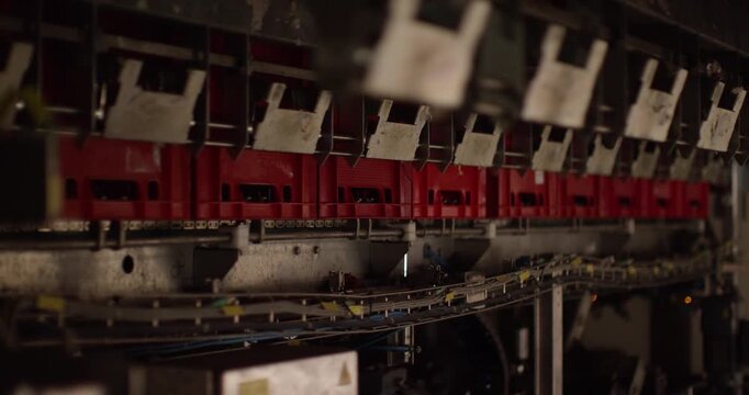 Red plastic crates move through an automated conveyor system inside an industrial facility
