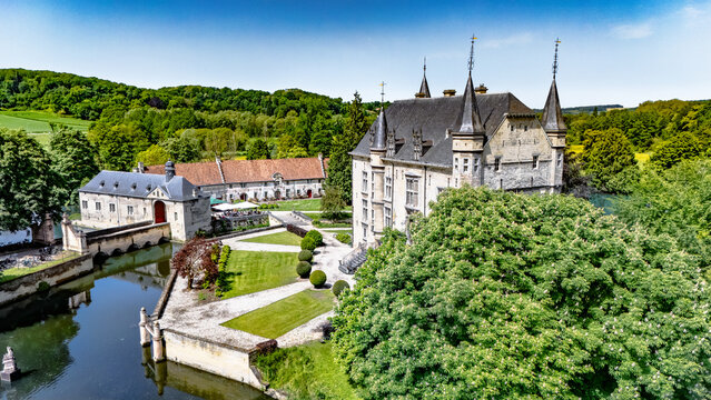 Aerial drone view of historic Schaloen castle surrounded by water moat, green gardens and beautiful nature landscape, Limburg, the Netherlands
