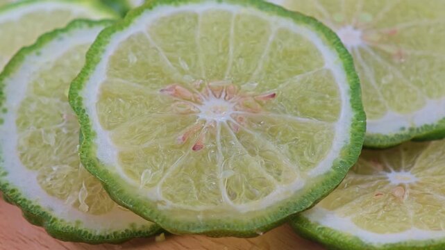 Sliced kaffir lime on wooden board.