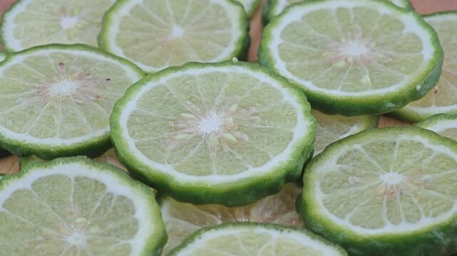 Sliced kaffir lime on wooden board.