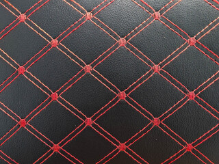 Obraz premium Black leather texture with red diamond stitching. Luxury car interior upholstery pattern.