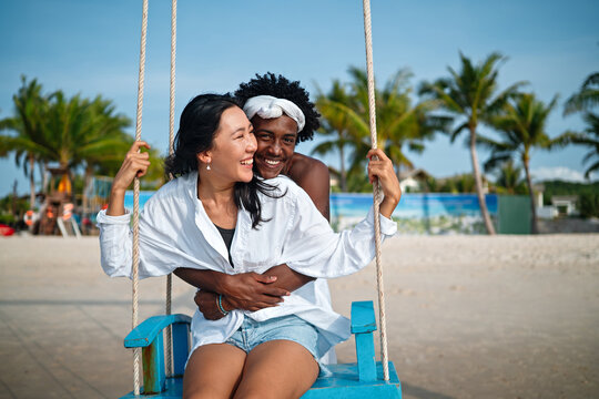 Interracial couple enjoying a romantic beach getaway, embracing love, laughter, and togetherness