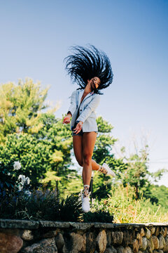 Woman with long curly hair whips it in the air