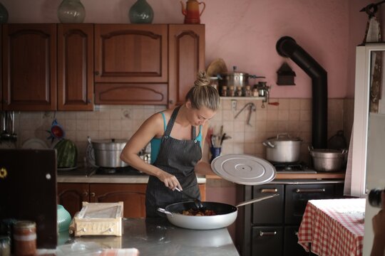 Young woman cooking food in a rustic kitchen
