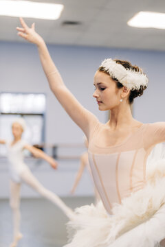 Young ballerina practicing elegant ballet pose in dance studio