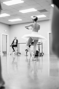 Ballerina performing pirouette in dance studio en pointe
