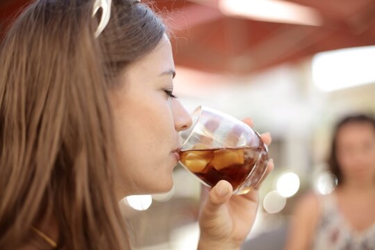Young woman enjoys a refreshing iced drink outdoors