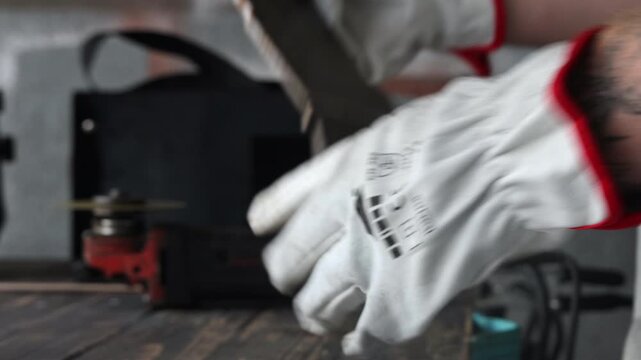 Selective focus on angle grinder cutting metal with bright flying sparks in a garage