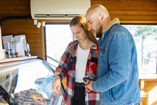 Young woman and man buying ice cream at a cafe