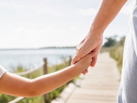 Momento de conexi&oacute;n entre un adulto y un ni&ntilde;o en un camino junto al agua