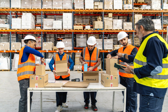 Warehouse team collaborating, preparing packages for shipping. Manager overseeing operations, ensuring efficient order fulfillment and supply chain