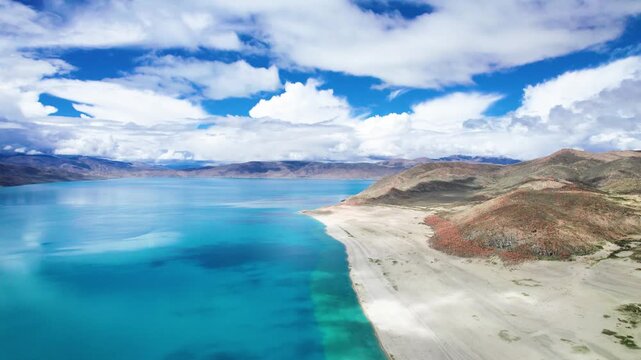 Drone view of Pegu Tso lake or Peikucuo in sunny day in Shigatse, Tibet, China, beautiful peaceful turquoise sea with mountains reflections in Xizang, 4k real time footage travel concept