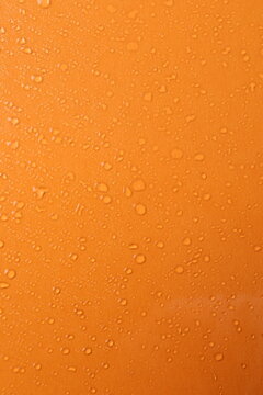 Water drops on orange background. vertical view