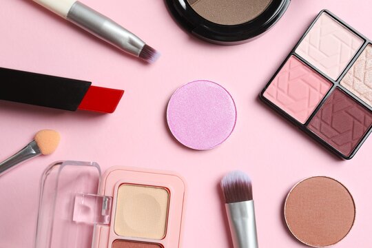 Group of modern makeup cosmetics products on pink background, top view