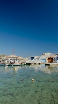 Mandrakia village Milos in Greece, where charming fishing boats sway gently in the turquoise waters. The vibrant village by the shore adds to the idyllic holiday atmosphere